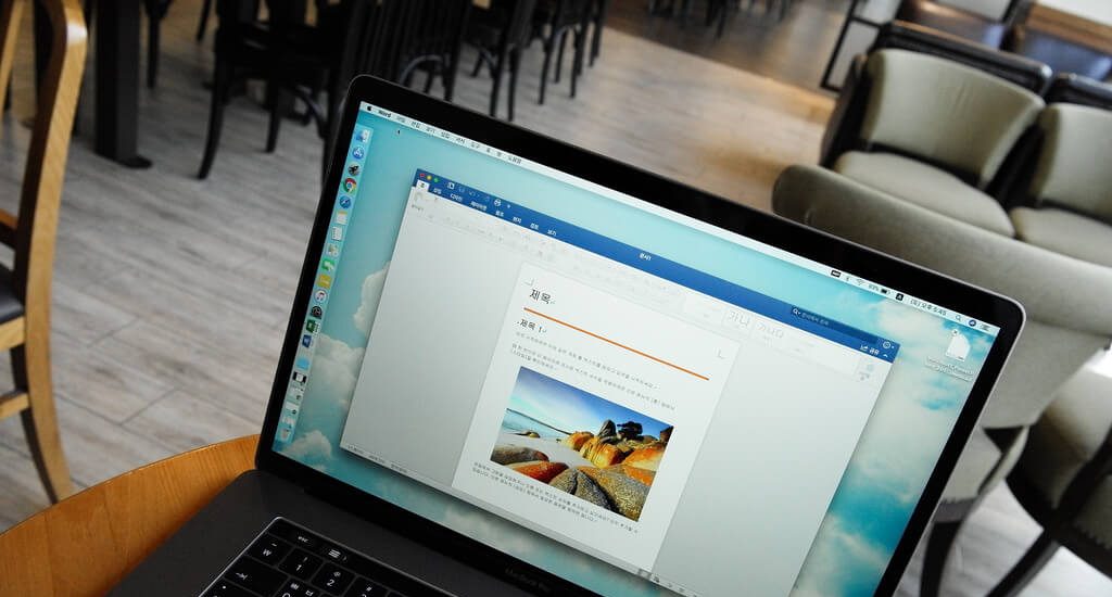 Microsoft Word open on a laptop in a cafe