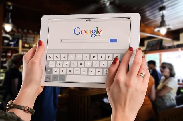 Female using an iPad to do a Google search while out